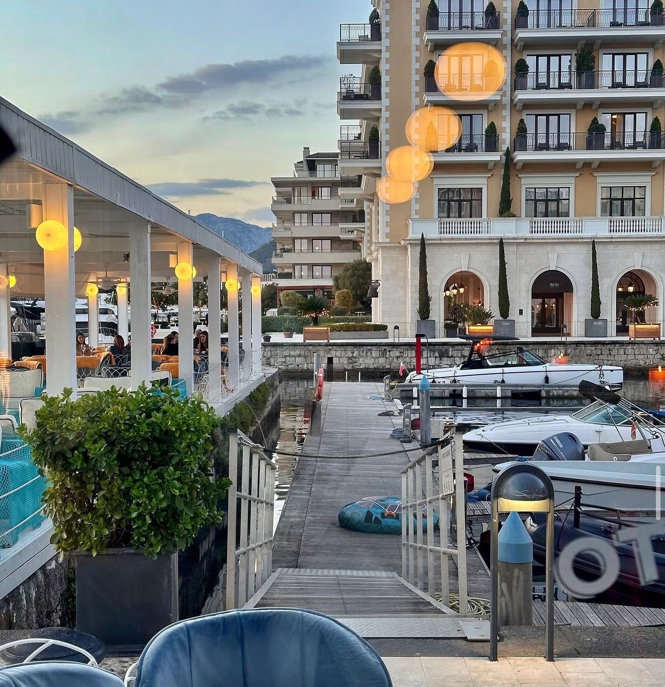 Terasa Al Posto Giusto u Porto Montenegru, Tivat: marina u sumrak, čamci na vezu i osvijetljene fasade