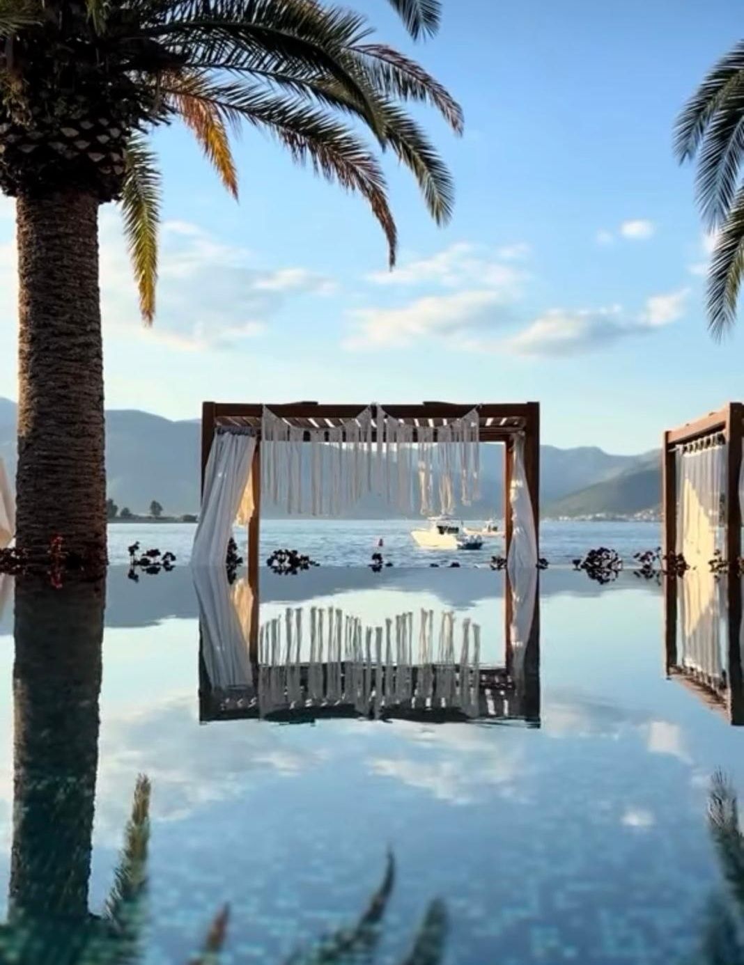 Kabana i palme u odrazu infinity bazena Monte Palm Beach, zaliv u Tivtu