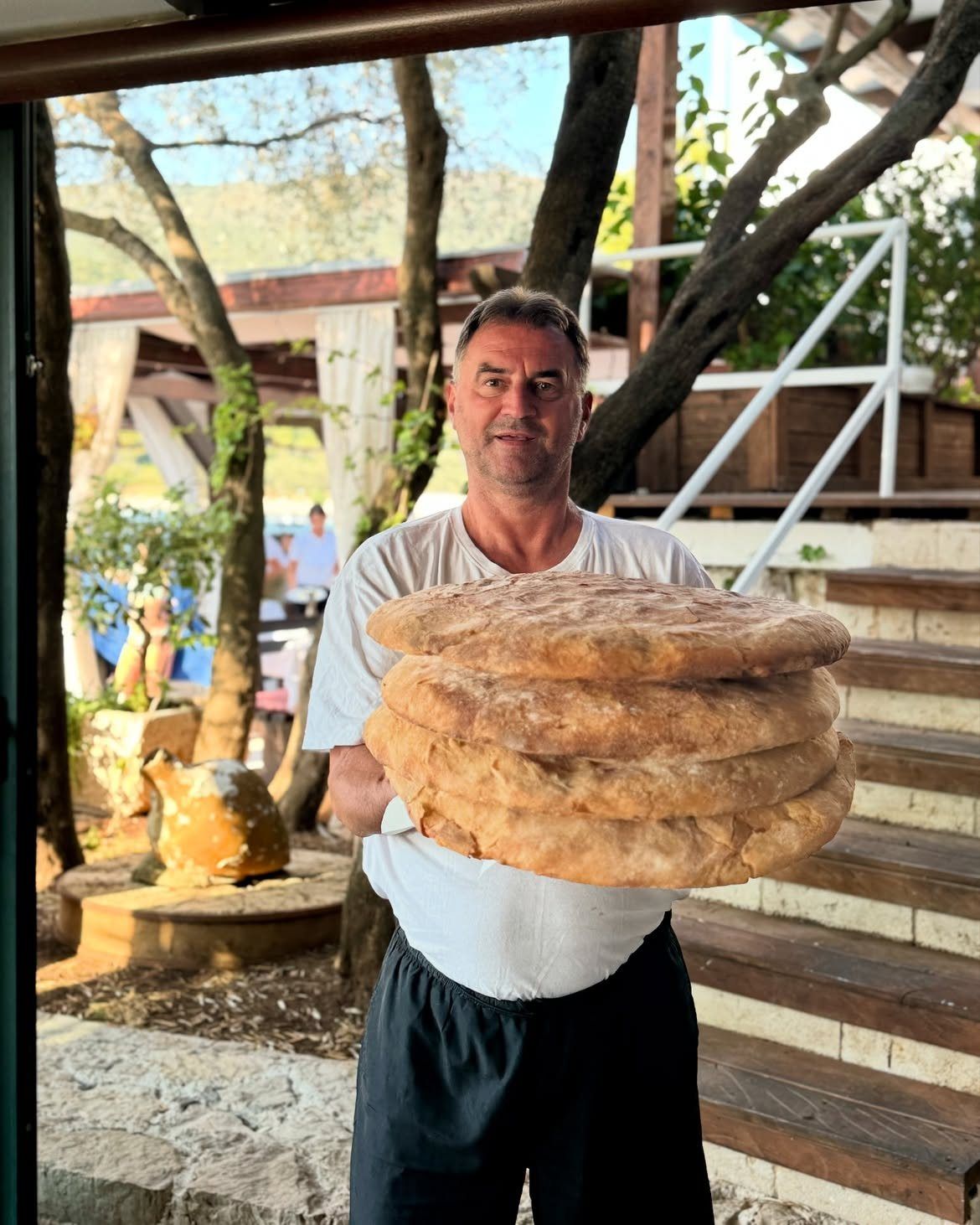 Domaćin Ribarskog Sela na Luštici nosi tople hljebove ispod sača